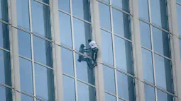 Urban climber Alain Robert beraksi memanjat Menara Lotte World di Seoul, Korea Selatan (6/6). Alain Robert memang terkenal karena hobinya memanjat bangunan tinggi, ia juga diberi gelar "French Spiderman". (AFP/Ed Jones)