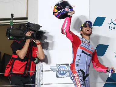 Pembalap tim Gresini Racing, Enea Bastianini berselebrasi di podium setelah memenangkan MotoGP Qatar di Sirkuit Internasional Lusail, Minggu (6/3/2022). Bastianini menyelesaikan balapan dengan waktu 42 menit 13,198 detik untuk merebut kemenangan perdana di kelas MotoGP. (KARIM JAAFAR/AFP)