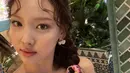 Nayeon juga tampil imut mengenakan gaya rambut keriting yang dikepang menggunakan scraf pendek. Poninya pun disisakan hanya sedikit yang dibuat keriting. Instagram @twicetagram