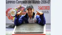 Jorge Lorenzo dengan plakat bertuliskan namanya setelah menjadi juara dunia 250cc tahun 2006-2007 di Montmelo. (AFP Photo/Lluis Gene)