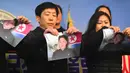 Warga Korea Utara yang membelot merobek foto pemimpin Korea Utara Kim Jong-Un saat konferensi pers di Majelis Nasional di Seoul (24/1). (AFP Photo/Jung Yeon-Je)