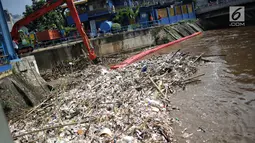 Alat berat (becko) beroperasi mengangkut sampah yang menumpuk di Pintu Air Manggarai, Jakarta, Selasa (26/2). Meningkatnya debit air Sungai Ciliwung menyebabkan terjadi penumpukan sampah di Pintu Air Manggarai. (Liputan6.com/Faizal Fanani)