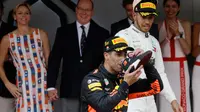 Pembalap Red Bull Daniel Ricciardo meminum sampanye dari sepatu saat merayakan kemenangannya di balapan Grand Prix Monaco F1, Monaco (27/5). Usai menangi Grand Prix Monaco, Ricciardo naik dua peringkat ke urutan ketiga klasemen Formula 1. (AP/Luca Bruno)