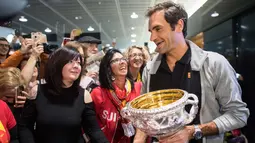 Petenis Swiss Roger Federer menyapa penggemarnya saat tiba di Bandara Zurich, di Kloten, Swiss, (30/1). Federer mengalahkan petenis Kroasia Marin Cilic 6-2, 6-7(5), 6-3, 3-6, 6-1. (Ennio Leanza/Keystone via AP)
