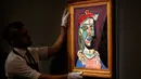 Petugas rumah lelang Sotheby menata lukisan Pablo Picasso bertema Marie-Therese Walter pada sesi pemotretan di London, Rabu (22/2). Lukisan Walter itu dibuat beberapa bulan setelah Picasso menyelesaikan karya besarnya, Guernica (1937). (AP/Frank Augstein)