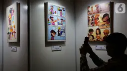 Pengunjung melihat karya komik dan kartun dalam kampanye bertajuk He For She di Jakarta, Senin (25/11/2019). Kampanye He For She merupakan gerakan solidaritas untuk memperjuangkan kesetaraan gender yang menggunakan pendekatan sistematis. (Liputan6.com/Fery Pradolo)