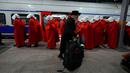Pengunjuk rasa yang mendukung hak-hak perempuan berpakaian seperti karakter dari serial TV "The Handmaid's Tale" saat melakukan perjalanan untuk memprotes rencana pemerintah baru Perdana Menteri Benjamin Netanyahu untuk merombak sistem peradilan di sebuah stasiun kereta api di Yerusalem, Israel, 1 Maret 2023. Mengacu pada fenomena yang berkembang, harian Inggris The Guardian menggambarkan penampilan para pelayan sebagai salah satu simbol paling kuat dari protes feminis kontemporer. (AP Photo/Ohad Zwigenberg)