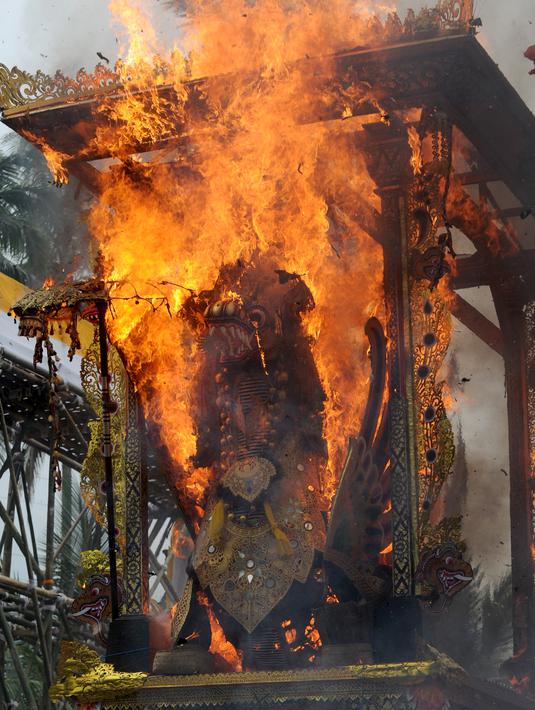 Peti berbentuk naga yang berisi jenazah anggota keluarga dari pahlawan nasional I Gusti Ngurah Rai dibakar dalam prosesi upacara Ngaben di Desa Carangsari, Bali, Senin (29/4/2019). Ribuan waga mengiringi kremasi terhadap jenazah putra kedua dan cucu dari I Gusti Ngurah Rai itu. (SONNY TUMBELAKA/AFP)