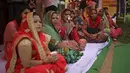 Seorang wanita Hindu India (tengah) minum teh yang dibuat dengan urin sapi selama acara yang diselenggarakan oleh kelompok agama Hindu untuk mempromosikan konsumsi urin sapi sebagai obat bat virus corona Covid-19 di New Delhi, India, Sabtu, (14/3/2020). (AP Photo/Altaf Qadri)