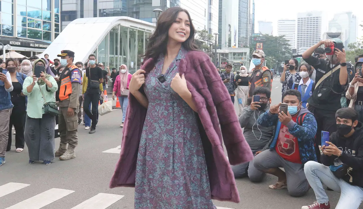 Artis Jessica Iskandar berlenggak-lenggok di zebra cross Dukuh Atas saat meramaikan Citayam Fashion Week di kawasan SCBD (Sudirman Citayam Bojong Gede Dukuh Atas), Dukuh Atas, Jakarta Pusat, Senin (25/7/2022). Jessica Iskandar tampak anggun mengenakan gaun bunga-bunga dengan luaran blazer bewarna ungu. (Liputan6.com/Herman Zakharia)