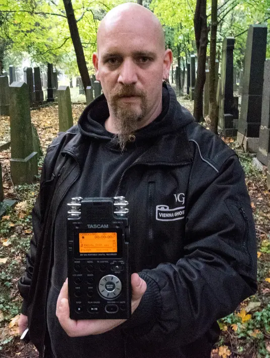 Seorang pemburu hantu menunjukkan alat detektor yang digunakan untuk mencari aktivitas gaib di pusat pemakaman tua di Wina, Austria, 20 Oktober 2016. Pemakaman ini disinyalir memiliki aura mistis yang kental dengan aktivitas makhluk halus (JOE KLAMAR/AFP)