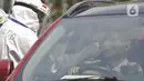 Petugas berpakaian APD lengkap melayani pasien yang secara mandiri melakukan swab test drive thru di halaman parkir rumah sakit di Jakarta, Rabu (12/5/2020). Swab test drive thru dilakukan untuk mendeteksi dan mencegah penyebaran virus corona COVID-19. (Liputan6.com/Johan Tallo)
