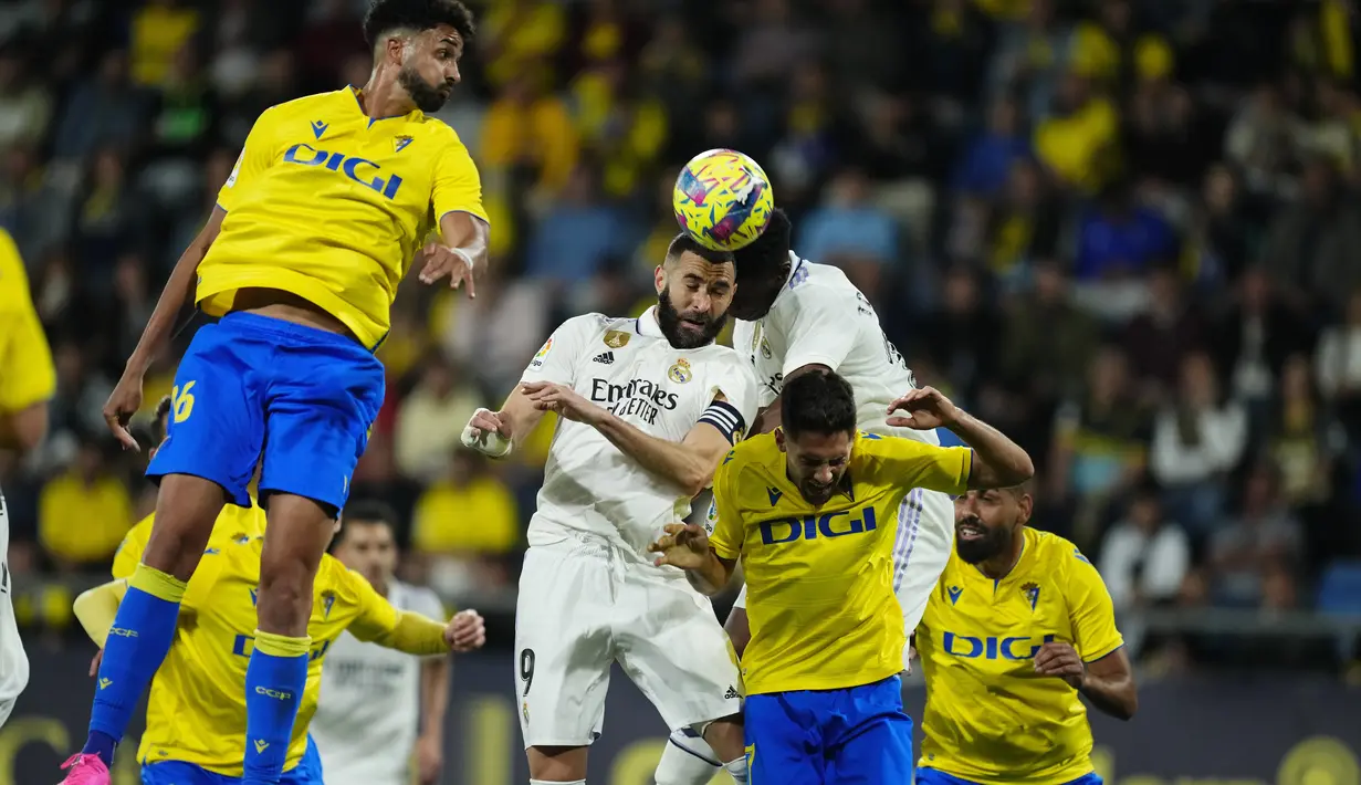 Penyerang Real Madrid Karim Benzema dan Eduardo Camavinga bersaing dengan penyerang  Cadiz Ruben Sobrino pada pekan ke-29 La Liga musim 2022/2023 di Stadion Nuevo Mirandilla, Minggu (16/4/2023) dini hari WIB. (AP Photo/Jose Breton)