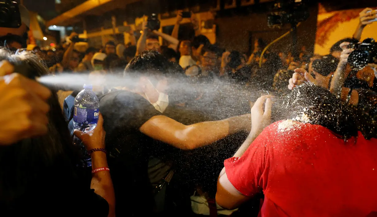 Polisi menggunakan semprotan merica untuk menghadapi pengunjuk rasa yang berdemonstrasi di Hong Kong, Minggu (6/10). Massa menentang intervensi Bejing untuk melarang dua aktivis pro-kemerdekaan menjabat sebagai anggota parlemen. (REUTERS/Tyrone Siu)