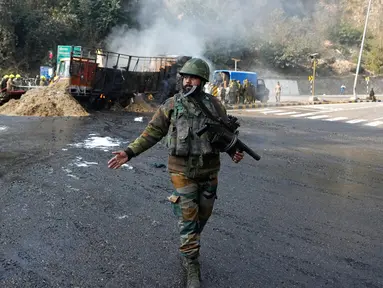 Seorang tentara India berjalan melewati lokasi baku tembak di Nagrota, Jammu-Srinagar, Kashmir yang dikuasai India, 28 Desember 2022. Polisi di wilayah Kashmir yang dikuasai India mengatakan pasukan pemerintah menewaskan empat tersangka militan dalam baku tembak tersebut. (AP Photo/Channi Anand)