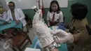 Dokter bersiap memberikan suntikan imunisasi di SDN 11 Pagi, Lubang Buaya, Jakarta, Selasa (4/10). Kegiatan ini untuk mewujudkan Indonesia bebas dari kanker serviks. (Liputan6.com/Faizal Fanani)