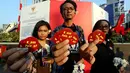 Aktivis dari Komisi Untuk Orang Hilang dan Korban Tindak Kekerasan (Kontras) menunjukan stiker saat melakukan aksi damai dengan memberikan bunga kepada warga di kawasan MH. Thamrin, Jakarta, Rabu (30/08). (Liputan6.com/Johan Tallo)