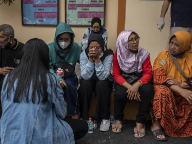 Keluarga dan kerabat korban tragedi Stadion Kanjuruhan menunggu di luar sebuah rumah sakit di Malang, Jawa Timur pada 2 Oktober 2022. Sedikitnya 174 orang tewas di stadion sepak bola Indonesia ketika ribuan penggemar tuan rumah yang marah menyerbu lapangan dan polisi menanggapi dengan gas air mata yang memicu desak-desakan, kata pihak berwenang pada 2 Oktober. (AFP/Juni Kriswanto)