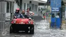 Pelajar dibantu mobil amfibi melewati genangan air di depan kampus UKRIDA, Jakarta, Selasa (21/1). Hujan deras sejak malam tadi, membuat sejumlah wilayah Jakarta tergenang air banjir. (Liputan6.com/Gempur M Surya)
