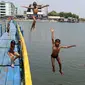 Sejumlah anak melompat saat bermain air dekat tanggul laut Muara Baru di Penjaringan, Jakarta Utara, Minggu (1/9/2019). Anak-anak memanfaatkan sisi tanggul laut raksasa (giant sea wall) sebagai   tempat  bermain alternatif. (merdeka.com/Arie Basuki)