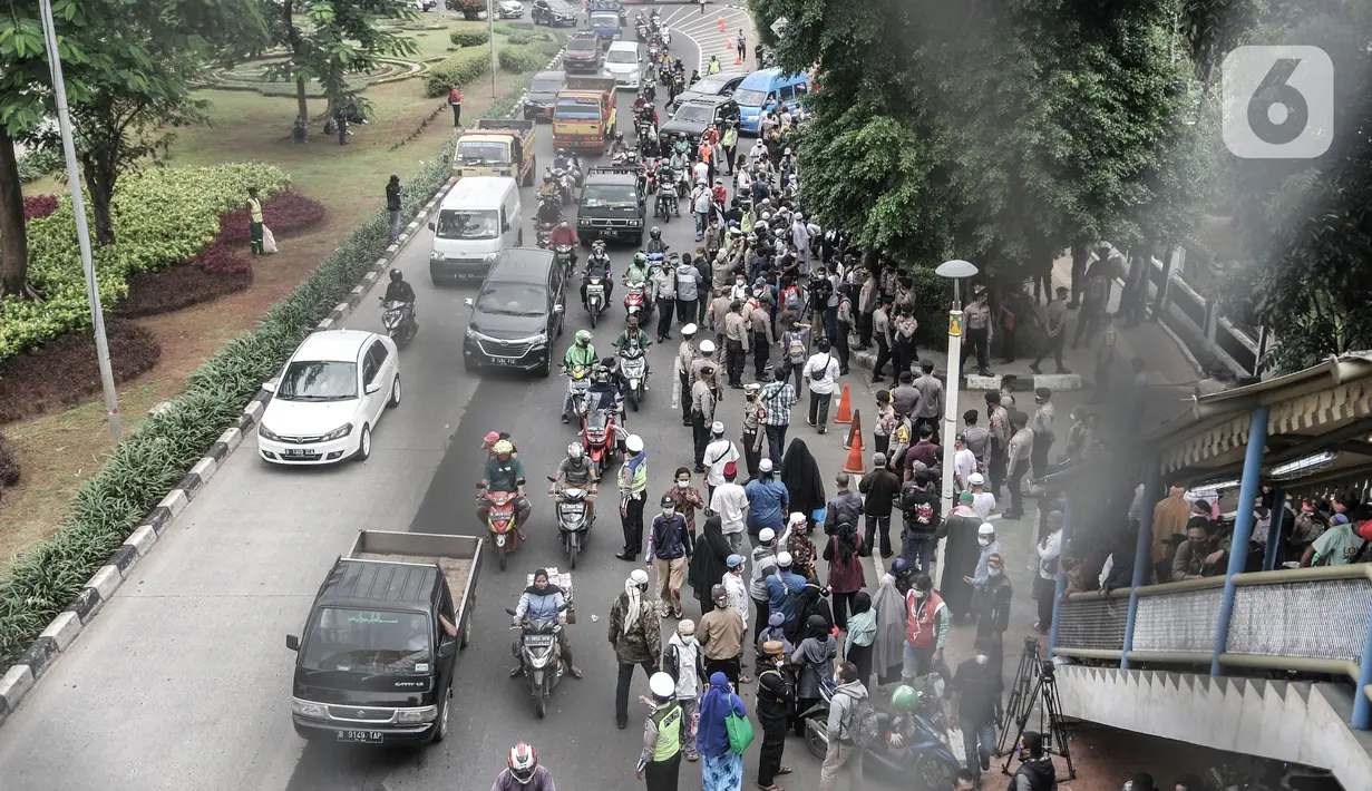 Massa pendukung memadati Pengadilan Negeri Jakarta Timur saat sidang perdana Rizieq Shihab, Jakarta, Selasa (16/3/2021). Massa mendatangi PN Jakarta Timur untuk menyaksikan sidang Rizieq Shihab terkait kasus kerumunan dan tes usap meski digelar secara virtual. (merdeka.com/Iqbal S. Nugroho)
