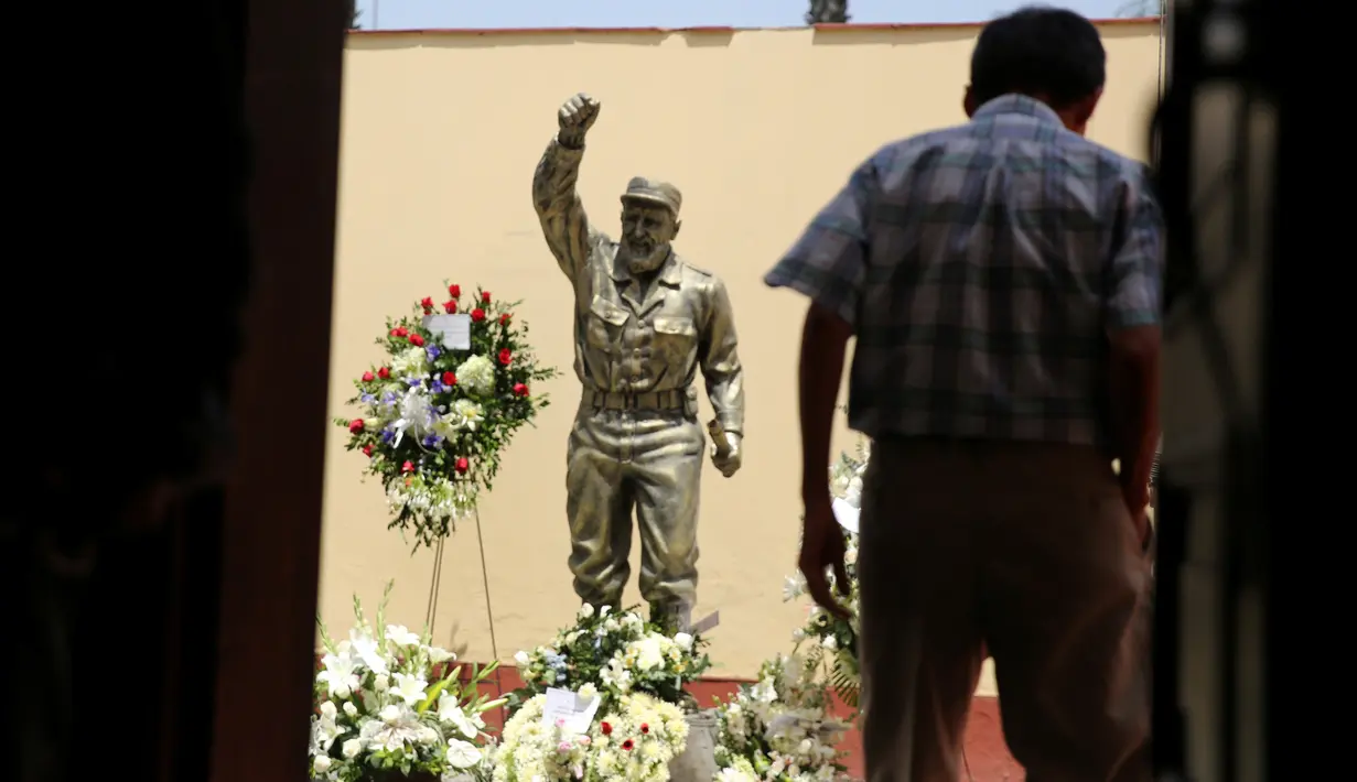 Karangan bunga diletakkan di dekat patung Fidel Castro setelah pengumuman kematiannya di Kedubes Kuba di Lima, Peru, Senin (28/11). Pemimpin revolusioner Kuba Fidel Castro meninggal dunia pada usia 90 tahun pada 25 November kemarin. (REUTERS/Mariana Bazo)