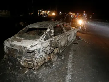 Sebuah mobil hangus terbakar usai terjadi tabrakan dengan mobil tangki pembawa gas kimia di Kenya, Minggu (11/12). Dikabarkan lebih dari 30 orang tewas dalam peristiwa nahas tersebut. (REUTERS / Stringer)