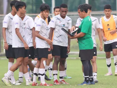 Pelatih Timnas Indonesia U-17, Bima Sakti, memberikan arahan kepada anak asuhnya saat sesi latihan di Lapangan ABC, Kompleks Gelora Bung Karno, Kamis (27/7/2023). (Bola.com/Abdul Aziz)