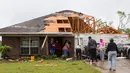 Tetangga dan keluarga membantu membersihkan rumah yang rusak di Monroe, La, (12/4/2020). Sedikitnya enam orang tewas akibat amukan tornado di negara bagian Mississippi pada Minggu (12/4) waktu setempat. (Nicolas Galindo/The News-Star via AP)
