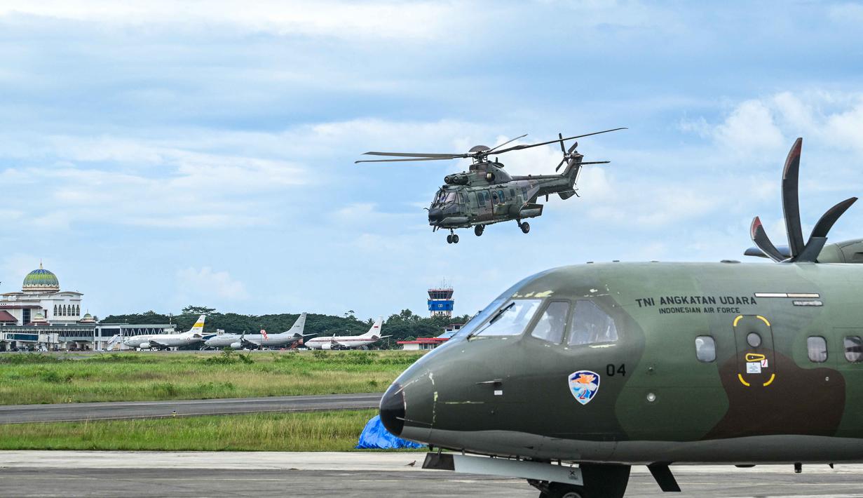 Percepatan dilakukan karena banyak warga terdampak yang belum terdistribusi bantuan logistik, terutama mereka yang tinggal di wilayah-wilayah terisolasi. Tampak dalam foto, sebuah helikopter berangkat untuk mengirimkan bantuan kepada korban banjir di Pangkalan Tentara Nasional Indonesia (TNI) Angkatan Udara (AU) di Blang Bintang, Provinsi Aceh, pada Minggu 7 Desember 2025. (Chaideer MAHYUDDIN/AFP)