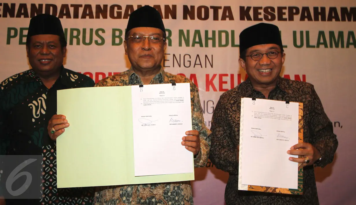 Ketua Umum PBNU, Said Aqil Siradj (tengah),  Ketua Dewan Komisioner  OJK Muliaman D. Hadad memegang lembar kerja sama, Jakarta, (29/2). Kerjasama juga terkait pengembangan lembaga keuangan mikro syariah..  (Liputan6.com/Angga Yuniar)