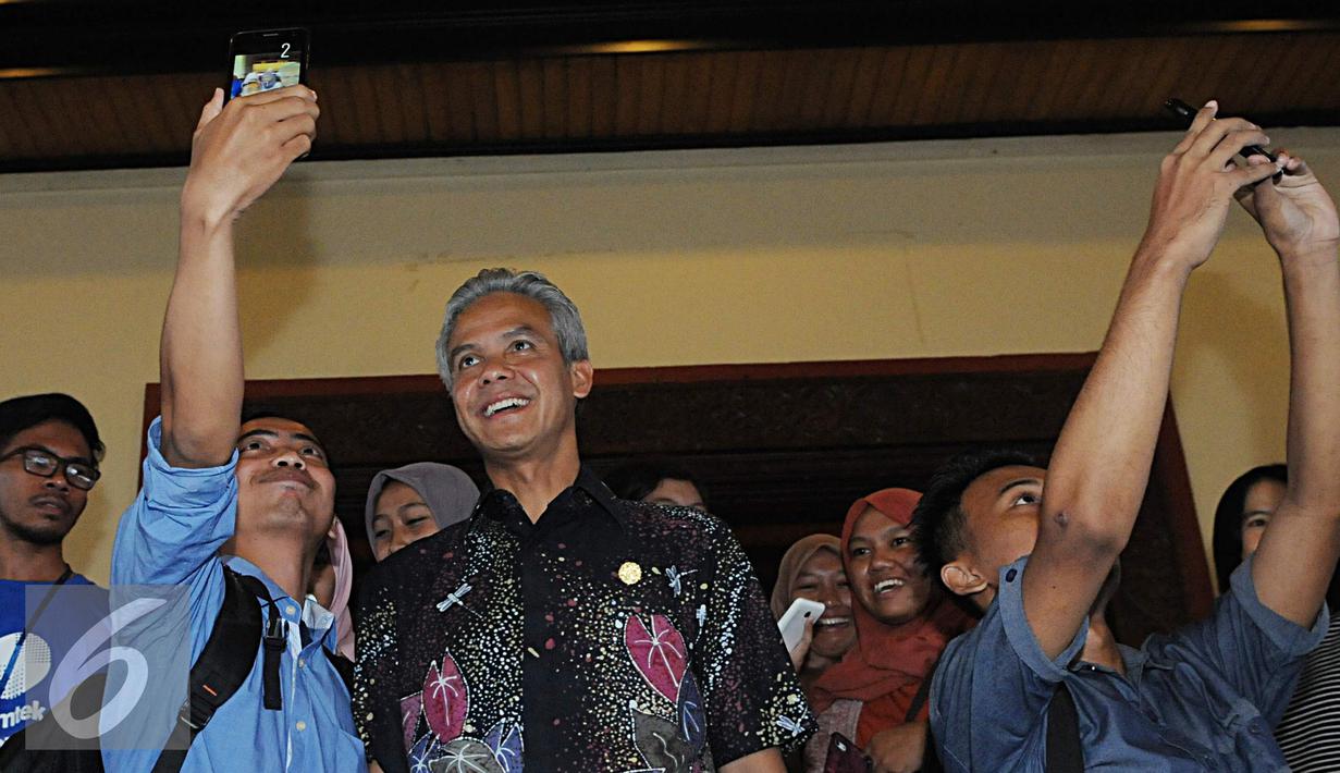 Gubernur Jawa Tengah Ganjar Pranowo berfoto bersama mahasiswa usai acara saat EGTC 2016, Yogjakarta, Kamis (3/11). Ganjar Pranowo menjadi pembicara dalam acara terakhir EGTC 2016 yang digelar di UGM. (Liputan6.com/Helmi Afandi)