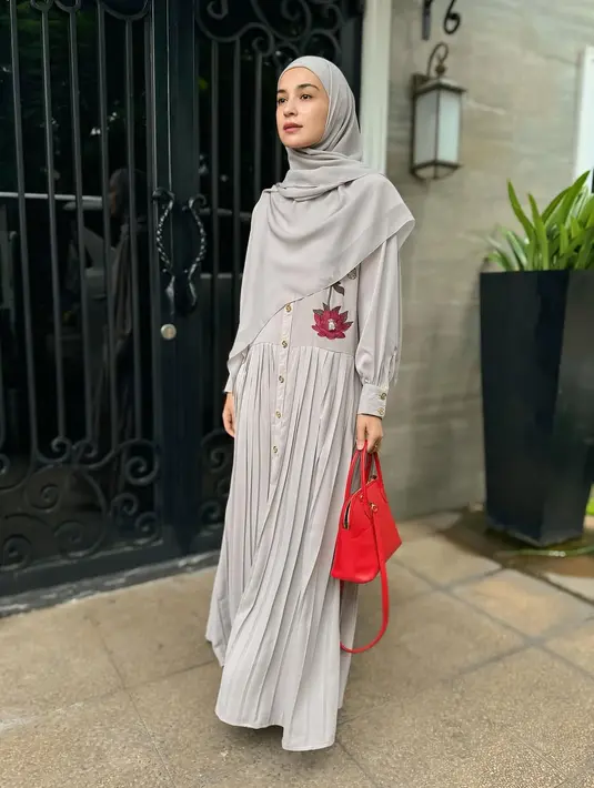 Dress panjang dengan aksen pleats tampak sempurna saat dipadukan dengan hijab segi empat yang salah satu sisinya lebih panjang untuk menutup dada. Gaya ini memberikan kesan feminin dan anggun. [@shireensungkar].