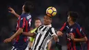 Pemain Juventus, Alex Sandro (tengah) berusaha menghalau bola dari sundulan pemain Crotone pada lanjutan Premier League di Allianz Stadium, Turin, Italy, (26/11/2017). Juventus menang 3-1. (AFP/Marco Bertorello)