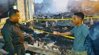 Polisi di Rokan Hilir melakukan olah tempat kejadian perkara kebakaran rumah yang menewaskan ibu dan anak. (Liputan6.com/M Syukur)