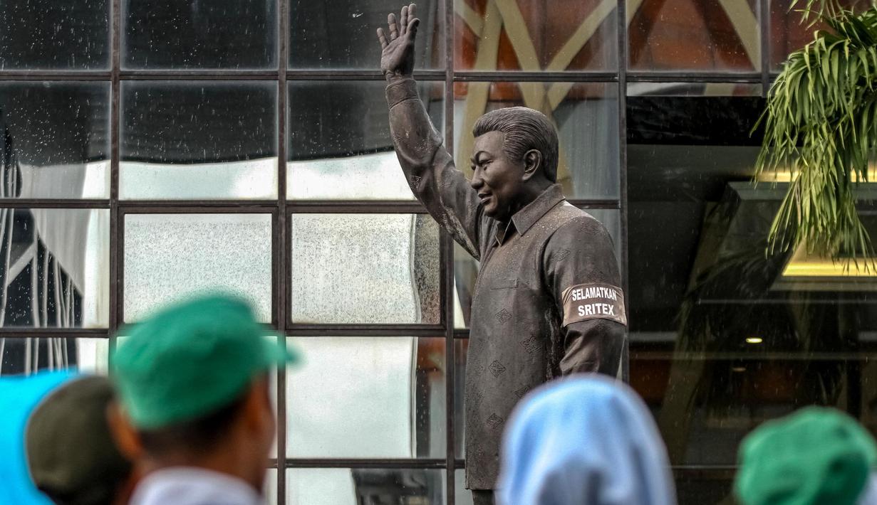 Sebuah ban lengan bertuliskan “Save Sritex” terlihat di lengan patung pendiri PT Sritex Tbk, Lukminto, di Sukoharjo, Jawa Tengah, pada tanggal 28 Februari 2025. (DIKA/AFP)