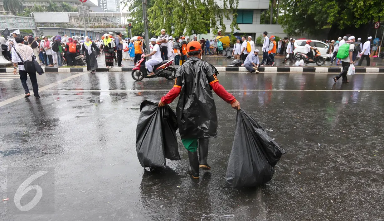  Seorang petugas kebersihan DKI Jakarta membawa sampah usai aksi damai 2 Desember di kawasan Jalan MH Thamrin, Jakarta, Jumat (2/12). Aksi damai 2 Desember digelar sebagai lanjutan dari aksi 4 November 2016. (Liputan6.com/Ferbian Pradolo)