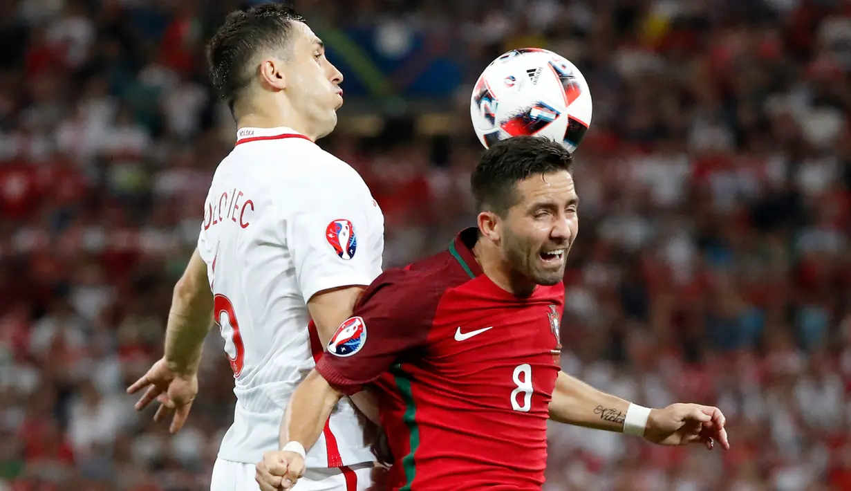 Gelandang Portugal Joao Moutinho (kanan) berebut bola udara dengan Tomasz Jodłowiec pada perempat final Piala Eropa di Stade Velodrome, Perancis, (1/7). Portugal melaju ke Semifinal usai menang adu penalti dengan skor 5-3. (REUTERS /Christian Hartmann)
