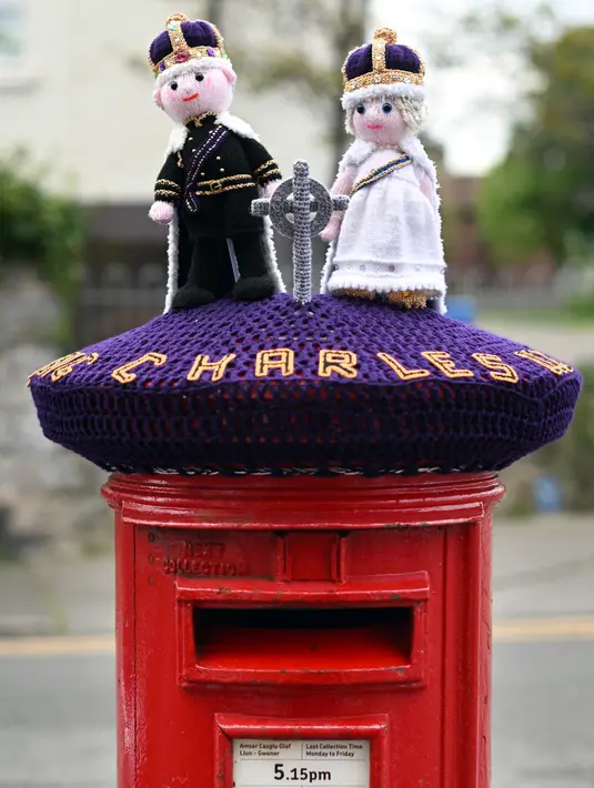 Foto yang diambil pada 2 Mei 2023 menunjukkan rajutan Raja Charles III dan Permaisuri Camilla yang dipajang di kotak pos di sebelahnya, di Rhyl, Wales utara, menjelang upacara penobatan. (Photo by Paul ELLIS / AFP)