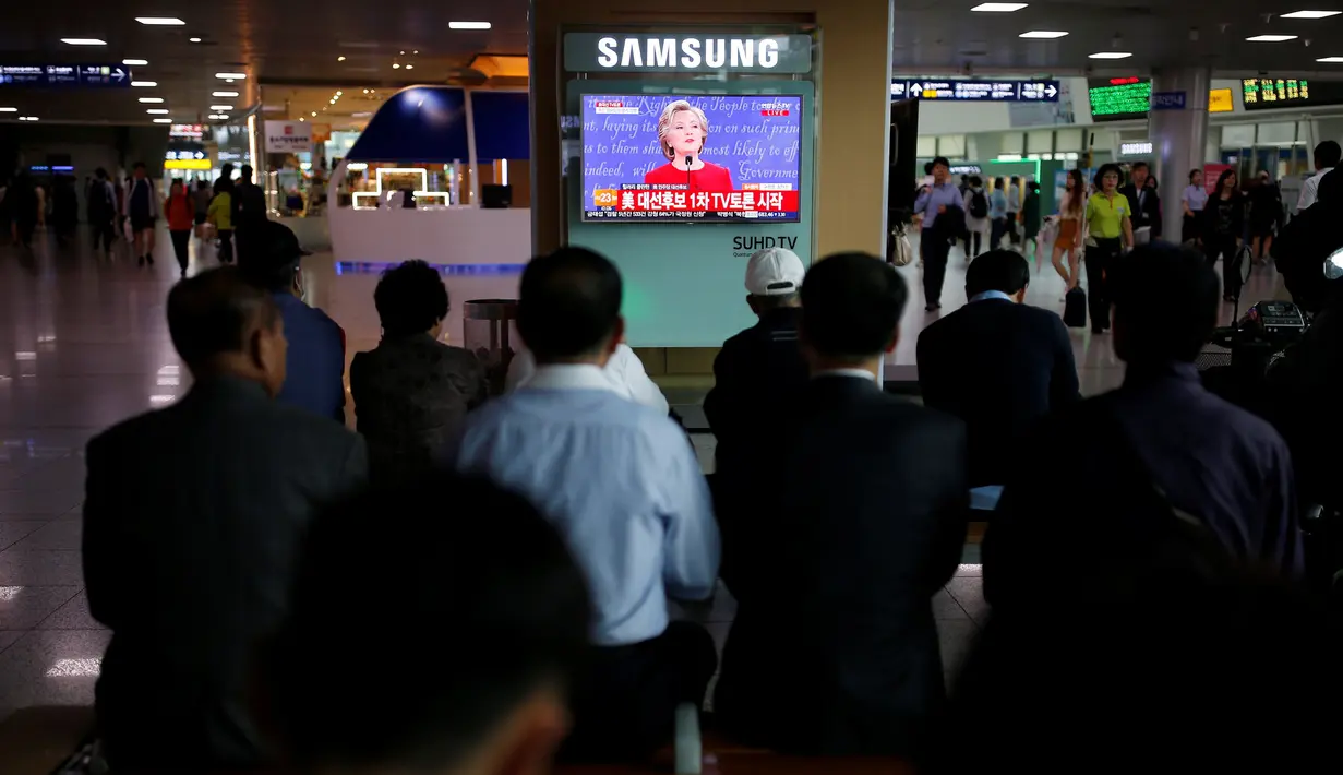 Antusiasme penduduk Korsel menyaksikan debat perdana capres AS dari Partai Republik dan Partai Demokrat, Donald Trump dan Hillary Clinton dari layar televisi di luar lokasi debat capres AS di Seoul, Korea Selatan, Selasa (27/9). (REUTERS/Kim Hong-Ji)