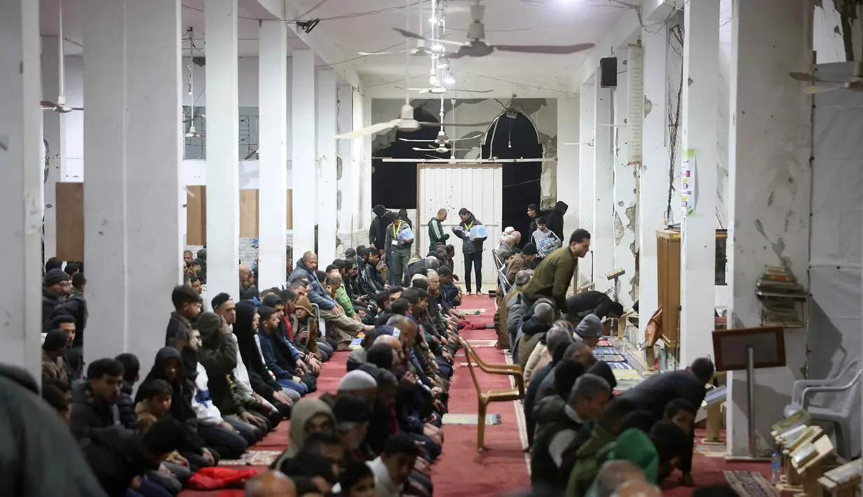 Ibadah atau amalan tersebut seperti beritikaf di Masjid; melaksanakan salat malam, baik itu tarawih maupun tahajud; membaca Al-Quran serta berzikir. Tampak dalam foto, umat Muslim melaksanakan salat malam di Masjid Mahaba yang rusak selama perang Israel-Hamas di Khan Yunis, Jalur Gaza selatan pada Senin 16 Maret 2026. (Bashar Taleb/AFP)