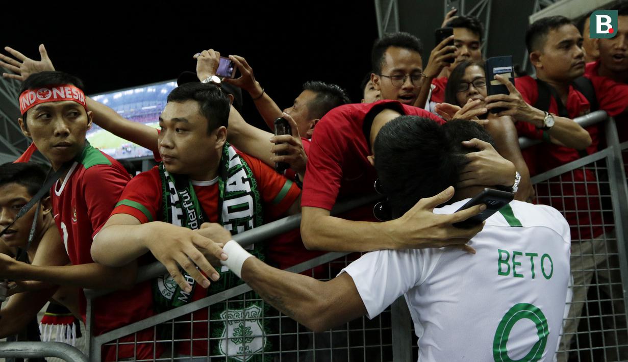 Seorang suporter memeluk striker Timnas Indonesia, Beto Goncalves, usai dikalahkan Singapura pada laga Piala AFF di Stadion Nasional, Singapura, Jumat (9/11). Singapura menang 1-0 atas Indonesia. (Bola.com/M. Iqbal Ichsan)