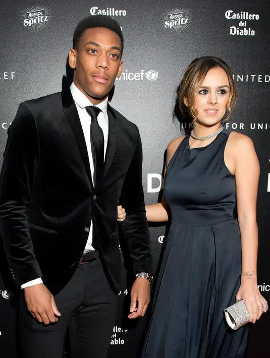Penyerang Manchester United, Anthony Martial (kiri) dan dan istrinya Samantha berpose di atas karpet merah saat mereka tiba untuk menghadiri "Inggris untuk UNICEF Gala Dinner" di Old Trafford, Manchester, Inggris, (29/11). (AFP PHOTO/OLI SCARFF)