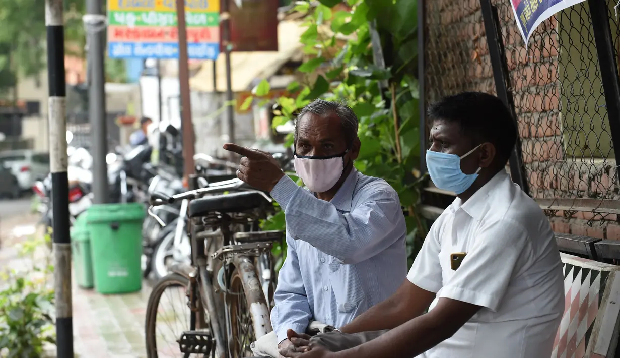 Pria yang mengenakan masker duduk di bangku umum di Ahmedabad, India, Senin (17/8/2020). Kasus kematian akibat Covid-19 di India telah melewati 50 ribu pada Senin (17/8), dengan kawasan pedesaan dan kota kecil yang lemah dalam sistem kesehatan menjadi daerah terdampak paling parah. (SAM PANTHAKY/AFP