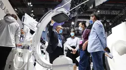 Seorang staf (keempat dari kanan) memperkenalkan sebuah mesin sinar X kepada para pengunjung dalam acara Pameran Alat Medis Internasional China (China International Medical Equipment Fair) di Shanghai, China, 19 Oktober 2020. (Xinhua/Fang Zhe)