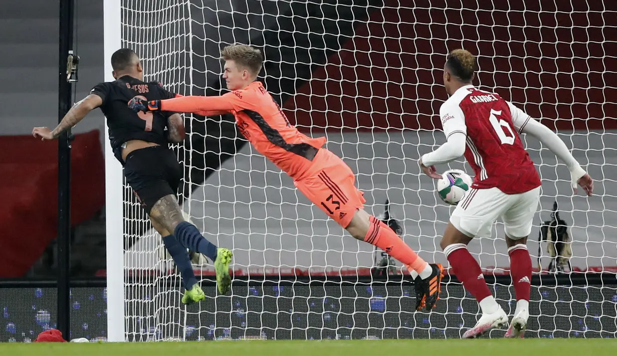 Gelandang Manchester City, Gabriel Jesus (kiri) menyundul bola melewati kiper Arsenal, Runar Alex Runarsson pada laga perempatfinal Piala Liga Inggris di Emirates Stadium, Rabu (23/12/2020) dini hari WIB. Man City ke semifinal Piala Liga Inggris lewat skor 4-1 atas Arsenal. (AP Photo/Frank Augstein)