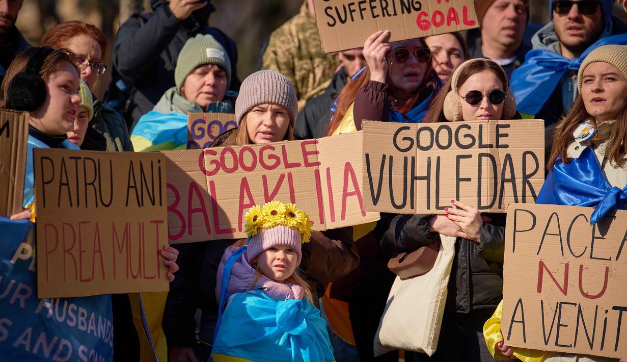 Orang-orang memegang spanduk saat anggota komunitas Ukraina menggelar protes menandai tahun keempat sejak dimulainya invasi skala penuh Rusia ke Ukraina di Bukares, Rumania, Minggu 22 Februari 2026. Sejumlah anggota komunitas Ukraina menggelar aksi protes di Bukares, Rumania. (AP Photo/Vadim Ghirda)