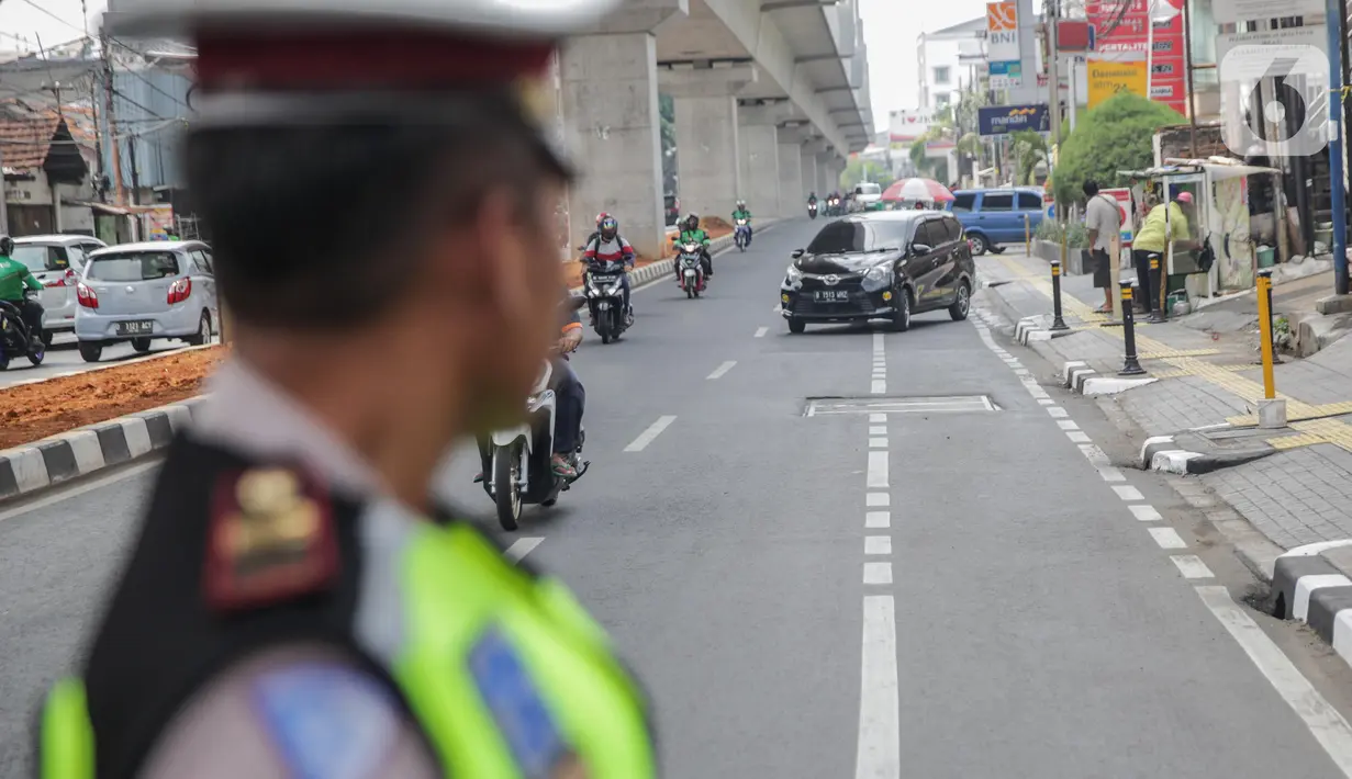 Petugas satlantas mensterilkan jalur sepeda di kawasan Blok A, Jakarta, Senin (25/11/2019). Mulai hari ini, polisi akan menilang para pengendara kendaraan bermotor yang nekat masuk dan melintas di jalur sepeda. (Liputan6.com/Faizal Fanani)