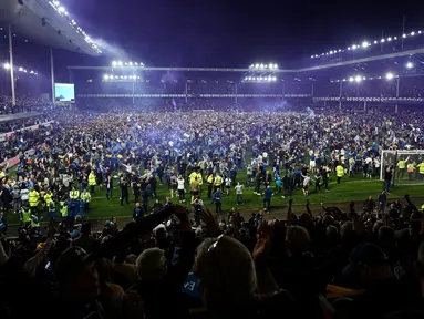 Suporter Everton menyerbu lapangan untuk merayakan akhir pertandingan Liga Inggris antara Everton dan Crystal Palace di Goodison Park di Liverpool, Inggris, 19 Mei 2022. Everton berhasil menang lewat come back dramatis 3-2 dan keluar dari zona degradasi Liga Inggris. (AFP/Oli Scarff)