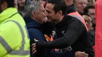 Pelatih Derby County, Frank Lampard, berpelukan dengan pelatih Manchester United, Jose Mourinho, pada Piala Liga Inggris di Stadion Old Trafford, Rabu (26/9/2018). Manchester United takluk adu penalti 9-10 (2-2) dari Derby County. (AFP/Paul Ellis)